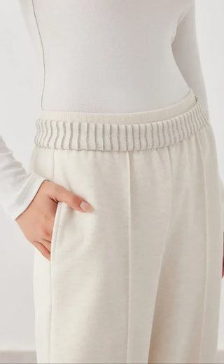 White knit pants waistband close-up with ribbed trim and gathered elastic