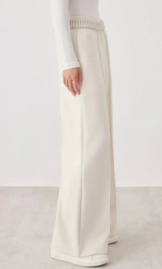 White wide-leg knit pants with straight drape and ribbed elastic waistband