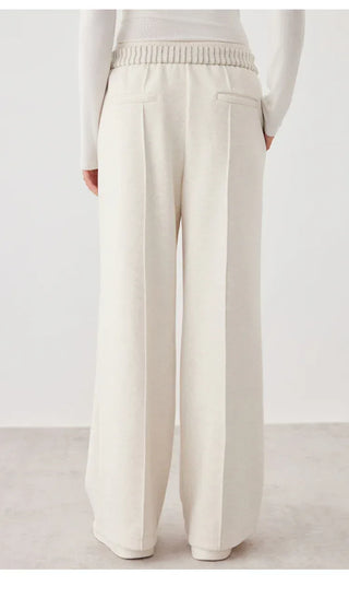 White wide-leg knit pants with front seam and two pocket openings; elastic waistband