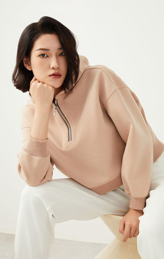 Khaki hoodie close-up: beaded half-zip placket and kangaroo pocket, soft knit cuffs