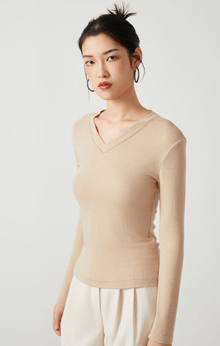 Apricot Tencel wool v-neck long-sleeve top, slim fit, worn over cream pants