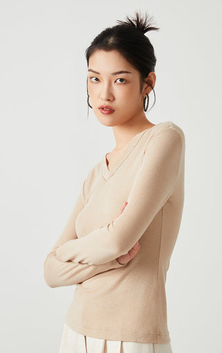 Apricot v-neck long-sleeve knit top with fitted sleeves and clean neckline