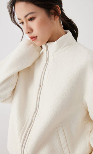 Close-up of white zip-front jacket collar and center zipper with beaded trim