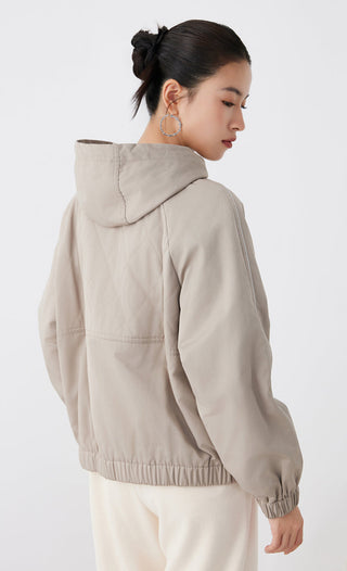 Light tan hooded quilted jacket with full sleeves, back/side view showing seam lines and pockets