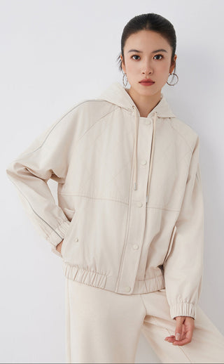 Light tan hooded quilted cotton jacket, front three-quarter view with snap placket and zip chest pocket
