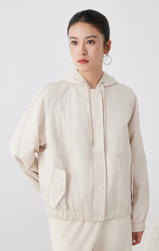 Light tan hooded quilted jacket with diamond quilting, drawcord hood, snap buttons, chest patch pocket