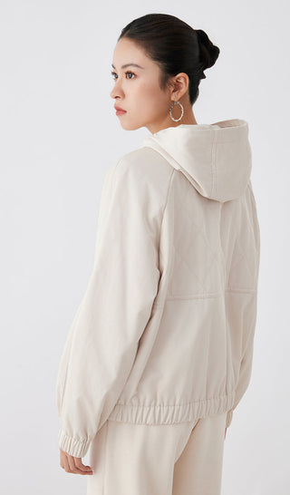 Light tan hooded quilted cotton jacket, back/side view with hood and ribbed hem cuffs