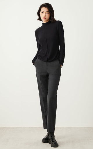 Dark gray tailored straight-leg pants worn with black sneakers, full body view