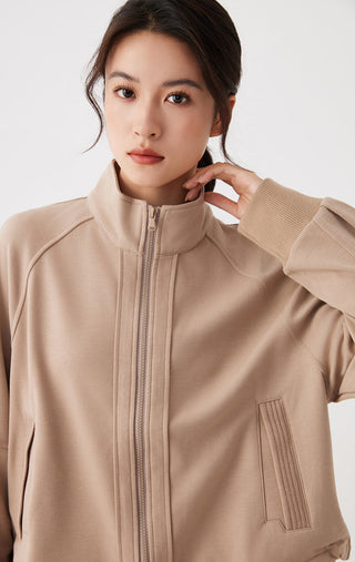 Khaki stand-collar zip jacket detail: high collar, center zipper, ribbed cuff