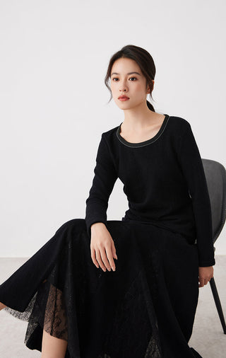 Black long-sleeve top with crew neck and draped front; paired look with tulle skirt overlay