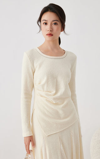 Beige long-sleeve top with crew neck and front drape; close front view