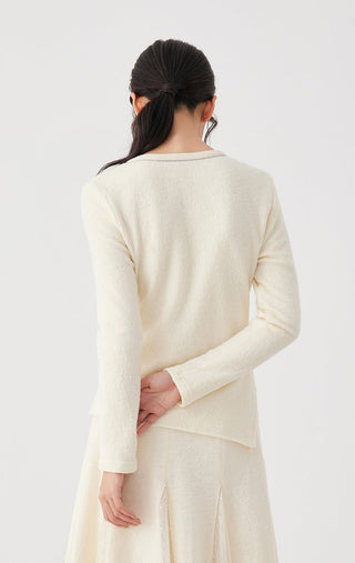 Back view of beige long-sleeve top with crew neck and layered drape seam detail