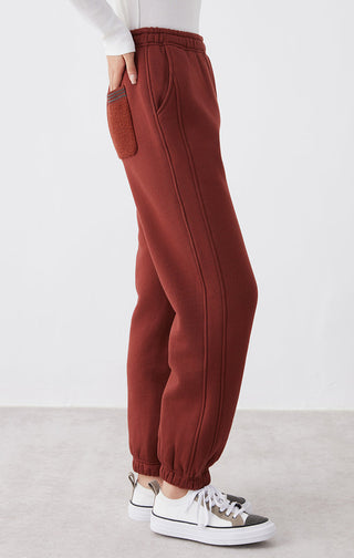 Ankela Red relaxed-fit pants with vertical seam detailing and elastic ankle cuffs