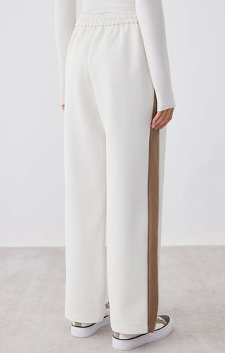 White wide-leg pants with tan side colorblock stripe and long front slit
