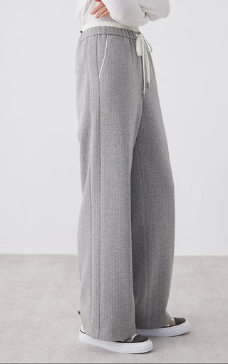 Light gray wide-leg pants, side view; elastic waistband with tie drawcord