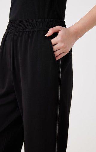 Black elastic-waist tailored pants detail with hand pocket and side seam