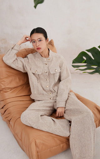 Beige linen button-front jacket with flap pockets and stitched paneling at the back