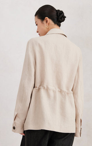 Beige linen utility shirt in back view with yoke seam and button cuffs