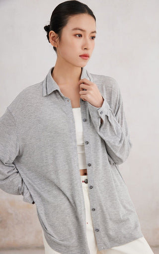 Light gray button-up shirt close-up: point collar, button placket, beaded collar trim detail