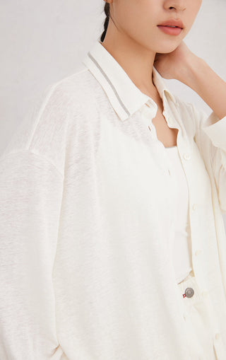 White button-up shirt close-up: point collar, button placket, beaded collar trim detail