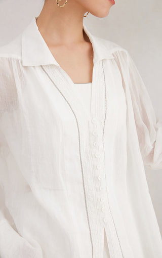 White shirt neckline detail: V placket, small buttons, and textured trim strip