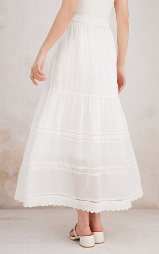White ramie tiered maxi skirt with ruffled tiers, embroidered bands, and lace-trim hem