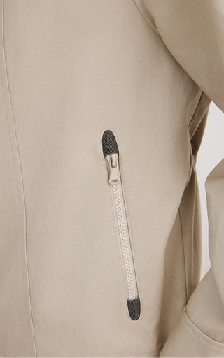 Front zipper detail on camel hooded jacket with black-trim tab and metal pull