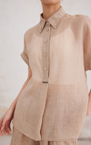 Apricot button-up shirt close-up: short sleeves, folded collar, round front buttons.
