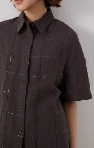 Close-up dark brown linen shirt front—buttons, grid stitch detail, short sleeves