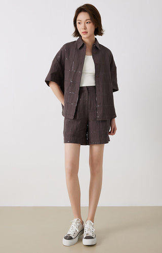 Dark brown linen short-sleeve shirt worn open; button front with grid stitch detail