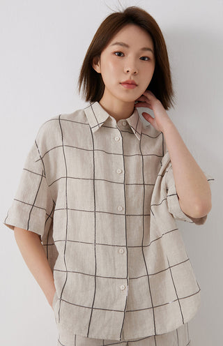 White linen short-sleeve shirt front with buttons and dark grid stitch pattern detail