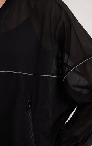Close-up of black hoodie fabric with contrast piping and front zipper area