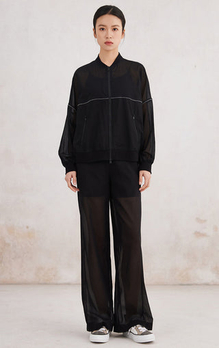 Black zip-up hoodie with contrast piping, worn with wide-leg black pants, front zip