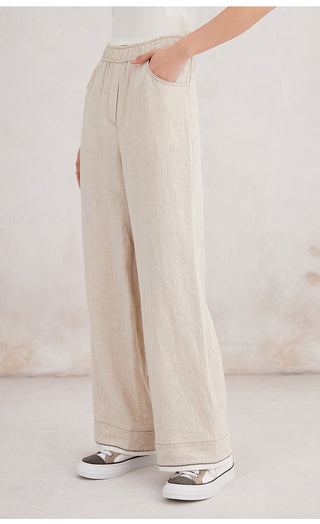Beige linen wide-leg trousers with side view showing tapered relaxed leg opening