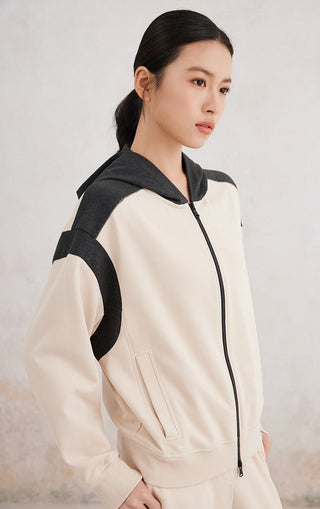 Side view apricot hoodie with black hood and curved black arm panel stripes