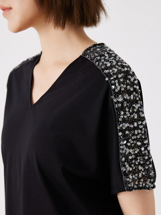 Close-up: black V-neck top with silver sequin sleeve shoulder trim