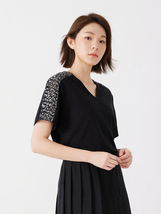Black cotton V-neck top with sequined shoulder trim and short sleeves, pleated hem