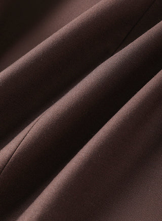 Dark brown wool-blend wrap vest fabric close-up, stitched seam edges