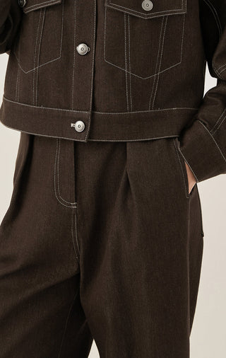 Brown wide-leg trousers with front button placket and contrast-stitched seams