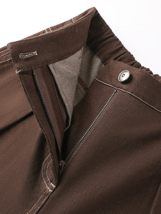 Brown trousers close-up: front zipper fly, button tab, and contrast topstitching