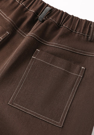 Brown wide-leg trousers close-up: elastic waistband and large rectangular flap pocket