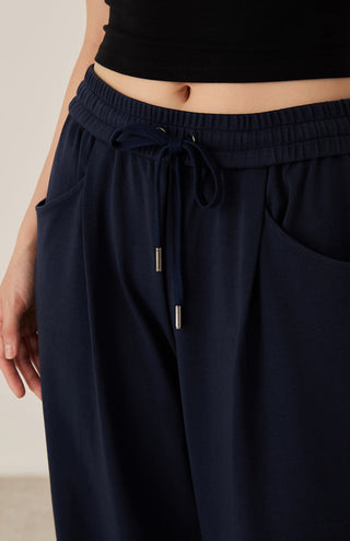 Dark blue elastic waist pants with drawstring and adjustable tips; side pocket seam