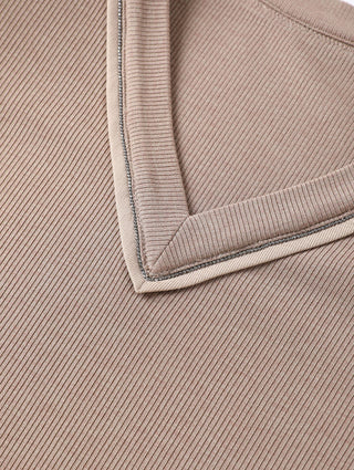 Detail view of brown V-neck trim with contrasting thread around neckline
