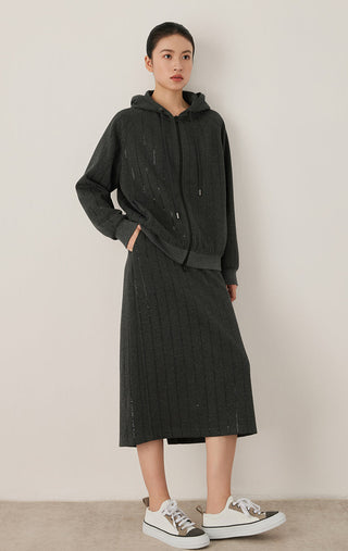 Graphite gray hooded zip jacket worn with skirt, featuring vertical sequin rows