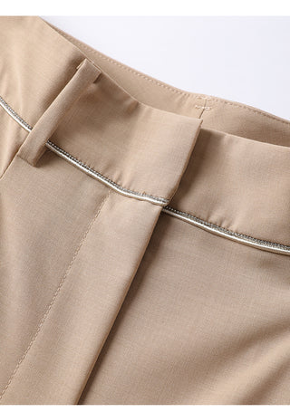 Waistband trim close-up on khaki tailored pants with belt loops and stitched details.