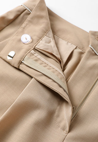 Front pocket and button closure detail on khaki tailored pants, with bar tacks.