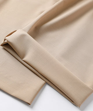 Khaki woven fabric close-up with folded drape, showing smooth texture and seam lines.