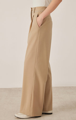 Side view of khaki wide-leg tailored pants with front crease and ankle-length hem.