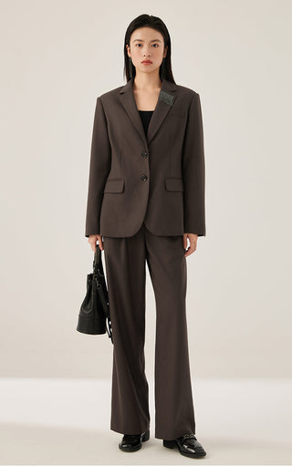 Dark brown wide-leg tailored pants with front creases and wide leg opening