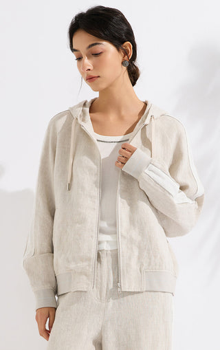 Beige linen hooded jacket with zip front and soft stand collar; model holding neckline